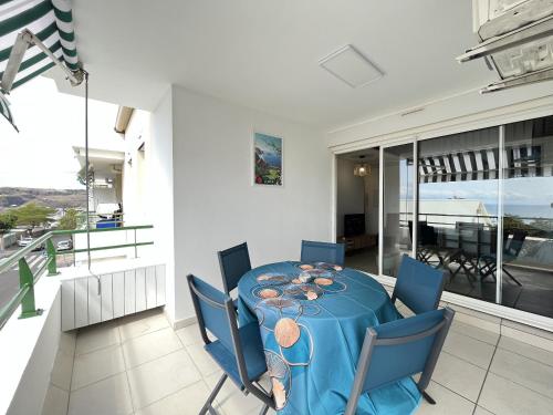 a dining room with a blue table and chairs at Alexandrin, superbe appt avec varangue et vue mer pour 3 personnes in Saint-Gilles les Bains