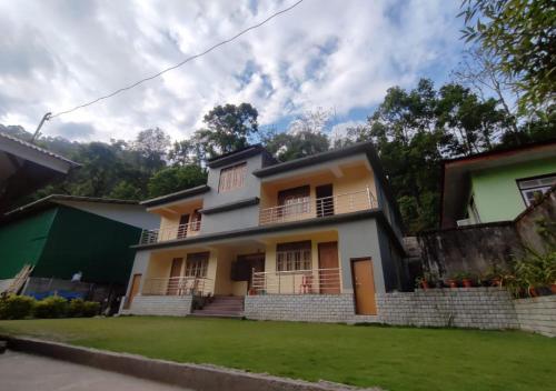 a house with a lawn in front of it at Lingtam Yangsel River Retreat by StayApart in Lingtām