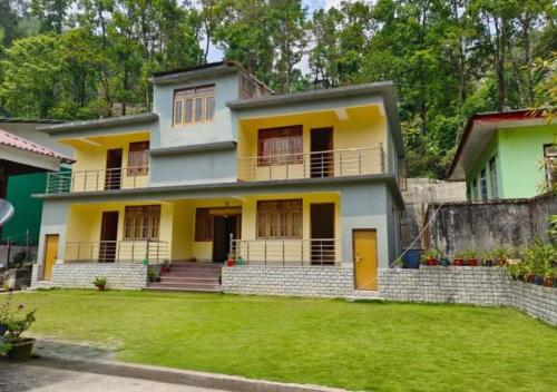 a house with a green lawn in front of it at Lingtam Yangsel River Retreat by StayApart in Lingtām