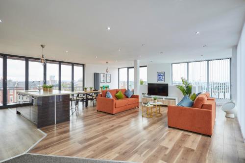 a living room with orange furniture and a kitchen and dining room at Host & Stay - The Knight Street Penthouses in Liverpool
