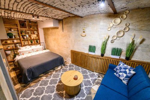 a bedroom with a bed and a blue couch at Arena View Premium Studio in Cluj-Napoca