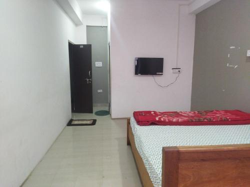 Pokój z dwoma łóżkami i telewizorem na ścianie w obiekcie OYO HOTEL RASU w mieście Imphal