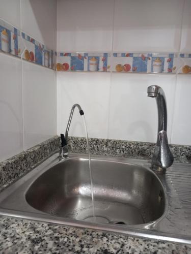 eine Küchenspüle mit einem Wasserhahn mit Wasser in der Unterkunft Olga`s Apartments, 300 Meter zu Playa del Cura in Torrevieja