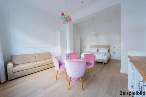 a living room with a table and chairs and a bed at Logierhaus am Rathaus in Norderney