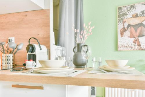 une table de salle à manger avec des assiettes et des verres dessus dans l'établissement Le Studio - Tramway, à Strasbourg