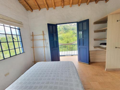 1 dormitorio con cama y ventana grande en Mountain view house, en Sasaima
