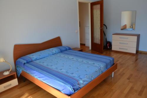 sypialnia z łóżkiem z niebieską kołdrą w obiekcie SUNA HOLIDAY w mieście Verbania