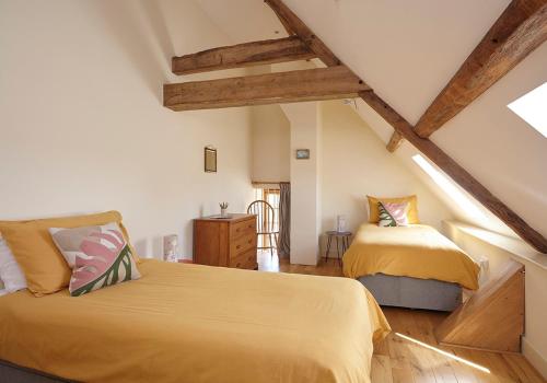 two beds in a attic bedroom with wooden beams at The Hayloft at Moor Farm in Godshill