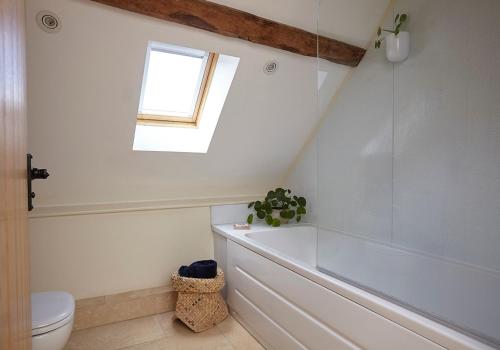 La salle de bains est pourvue d'une baignoire, de toilettes et d'une fenêtre. dans l'établissement The Hayloft at Moor Farm, à Godshill