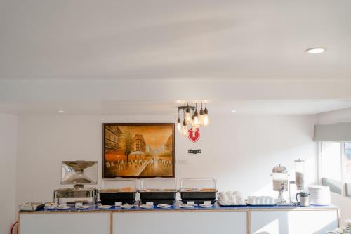 a kitchen with white walls and a counter with food at Hotel Asrani International in Secunderabad