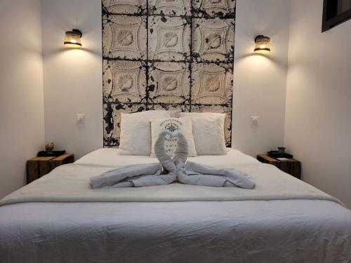 a bedroom with a large white bed with two lights at L'Escapade T1 de 30 m2 neuf. in Granville