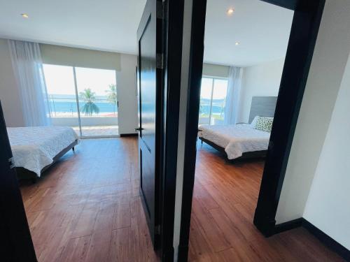 a bedroom with two beds and a view of the ocean at Puerto Azul Hotel in Puntarenas