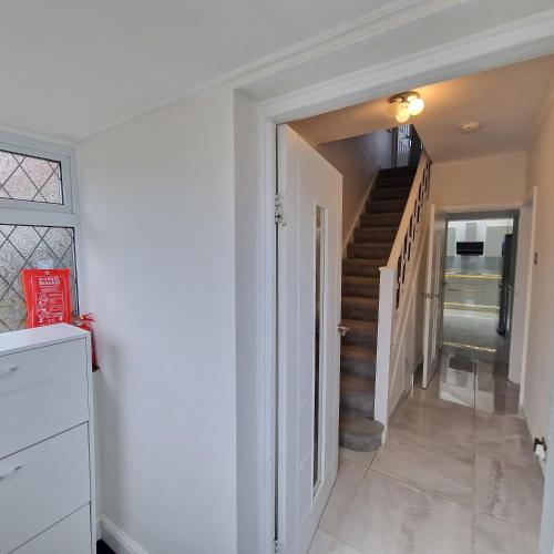 un pasillo con una escalera en una casa en Delightfully & Spacious Guest House in Farnworth, en Farnworth