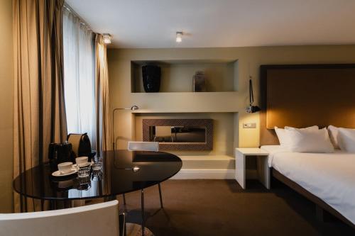 a hotel room with a bed and a table and a bed at Hotel Roemer Amsterdam in Amsterdam