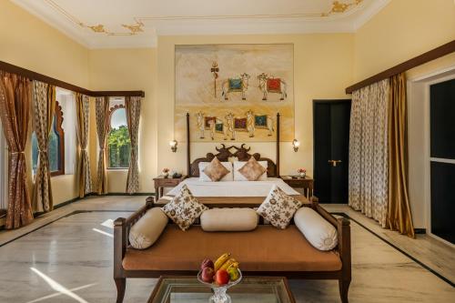 a bedroom with a bed and a couch at Sterling Jaisinghgarh Udaipur in Udaipur