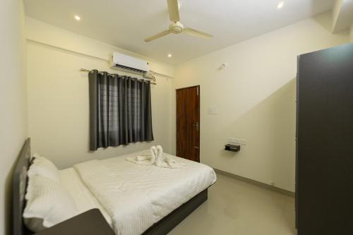 a bedroom with a bed with a ceiling fan at Fortune Inn in Erode