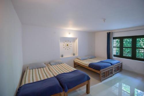 a bedroom with two beds and a window at Whitemist homestay in Somvārpet