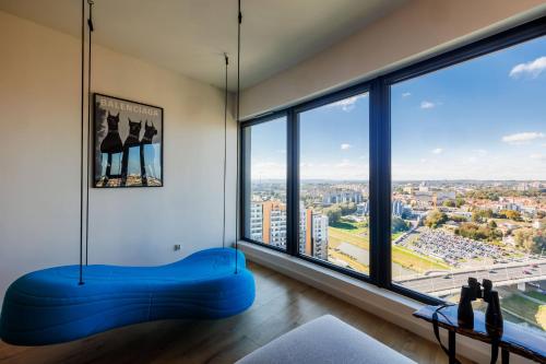 a room with a large window with a blue bench at Panorama Capital Skyline - 17 piętro in Rzeszów