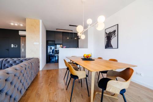 a kitchen and dining room with a wooden table and chairs at Panorama Capital Skyline - 17 piętro in Rzeszów