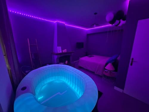Persan的住宿－Love Room avec Jacuzzi proche Paris et Roissy CDG，紫色客房内设有大浴缸的房间