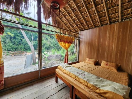 ein Schlafzimmer mit einem Bett und einem großen Fenster in der Unterkunft Dong Que Homestay in Ha Giang