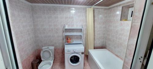 een kleine badkamer met een wasmachine en een wasmachine bij Guesthouses in Turkestan in Türkistan
