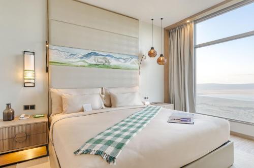 a bedroom with a large bed and a large window at Ngorongoro Lodge member of Melia Collection - The Leading Hotels of the World in Ngorongoro