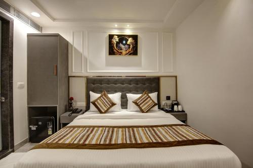 a bedroom with a large white bed with pillows at Hotel Kaca Inn-Traveller's Choice Awarded Best of the Best 2025 in New Delhi