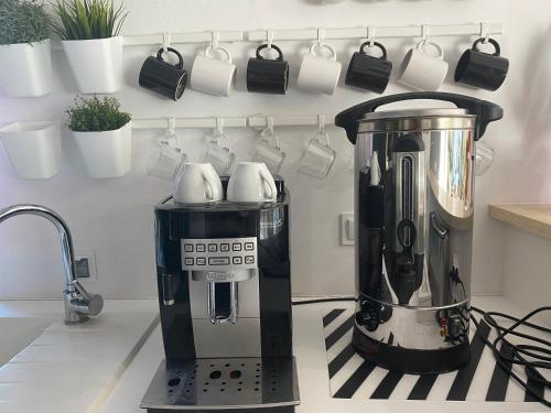 a coffee maker on a kitchen counter with cups on a rack at Borek in Medyka