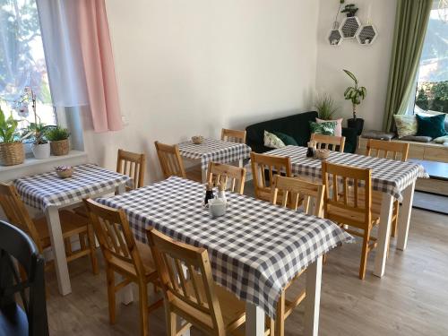 a dining room with tables and chairs and a couch at Borek in Medyka