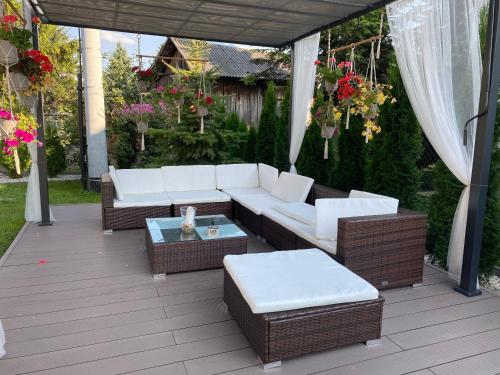 a patio with a white couch and tables and flowers at Borek in Medyka