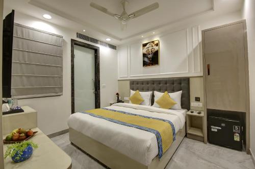 sypialnia z dużym łóżkiem z żółtą i niebieską pościelą w obiekcie Hotel Kaca Inn-by Haveliya Hotels w Nowym Delhi