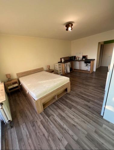 1 dormitorio con 1 cama y suelo de madera en Schöne Ferienwohnung in Leverkusen, en Leverkusen