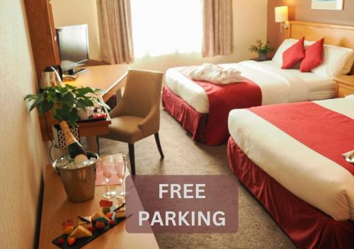 a hotel room with two beds and a free parking sign at Future Inn Cardiff Bay in Cardiff