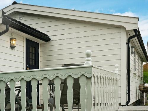 Casa blanca con porche con barandilla blanca en 4 person holiday home in Austrheim, en Bergsviki