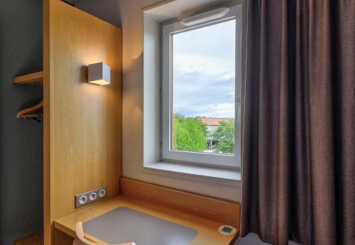 a room with a window and a window seat with a window at B&B HOTEL Beaune Sud 2 in Beaune