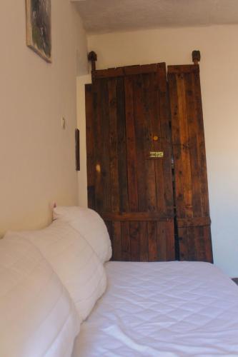 a bedroom with a bed with a wooden door at Riad Sahara Sunset Beach Douira Agadir in Douaïra