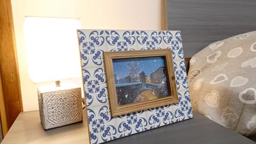 a picture frame sitting on a table next to a lamp at 20 VENTI in Angolo Terme
