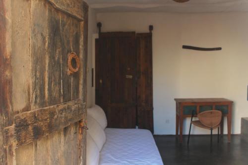 a bedroom with a wooden door and a bed at Riad Sahara Sunset Beach Douira Agadir in Douaïra