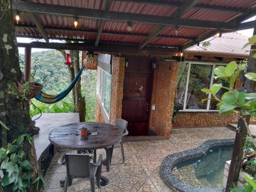 un patio con una mesa y una piscina en Mandalas Ecolodge, en Cerro Azul