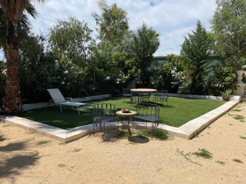 a yard with a table and chairs on a lawn at Maison d Hotes BLUE PALM Aix en PROVENCE in Aix-en-Provence
