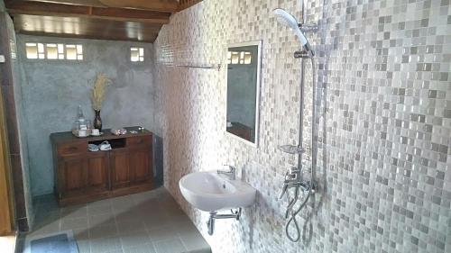 La salle de bains est pourvue d'un lavabo et d'une douche. dans l'établissement Bujak Permai Villa Matahari Lombok NTB, à Praya