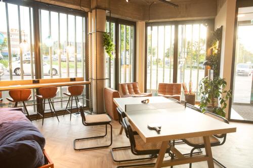 a room with a table and chairs and windows at LOGINN Hotel Waiblingen in Waiblingen