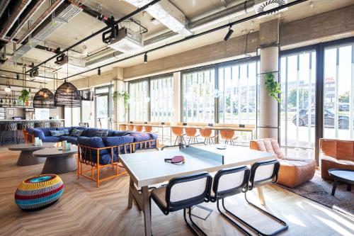 a large room with tables and chairs and windows at LOGINN Hotel Waiblingen in Waiblingen