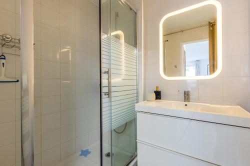 une salle de bain avec un lavabo et un miroir dans l'établissement La Domitienne - Premiere conciergerie, à Montpellier