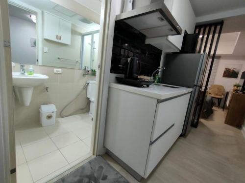 a small kitchen with a sink and a refrigerator at The Aces Crib at Azure North Pampanga in San Fernando