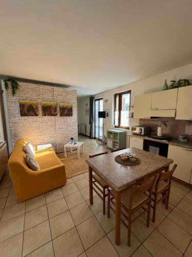 een woonkamer met een gele bank en een tafel bij Casa Nonna Elide 2 in Besozzo