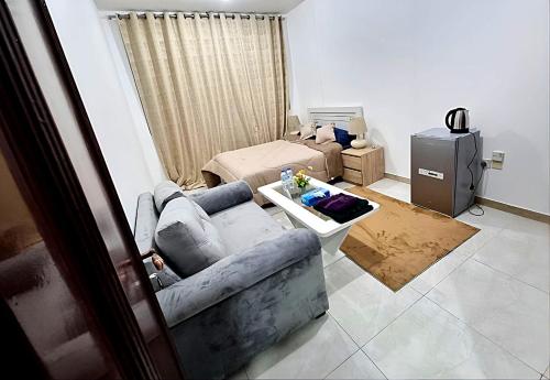 uma sala de estar com um sofá e uma televisão em Corniche AD - Extremely Unique Room em Abu Dhabi