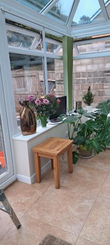 a greenhouse with a table and a vase on it at Cosy double room in Torquay