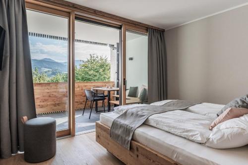 sypialnia z łóżkiem oraz balkon ze stołem w obiekcie DAS KIRCHBICHL - stylisch lässig, mit eigener Sauna w mieście Schliersee